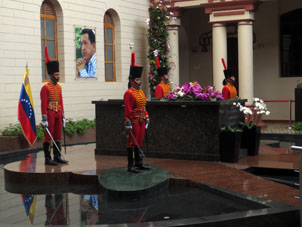 Могила Уго Рафаэля Чавеса Фриаса под портретом Симона Боливара с почётным караулом из двух гвардейцев мужчин и двух гвардейцев женщин, которые до своей смены стоят по два часа без движения.