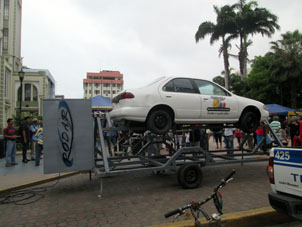 Автошкола устроила аттракцион на центральной площади в Мачале, где люди залезают в кабину, пристёгиваются ремнями, а установка их переворачивает.