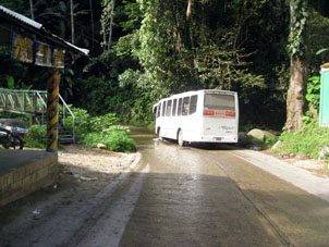 Автобус из Чорони пересекает речку, которая переливается через дорогу.