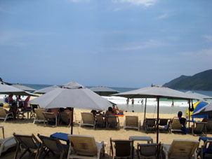На пляже берут в аренду зонтик-грибок, столик и пару лежаков.