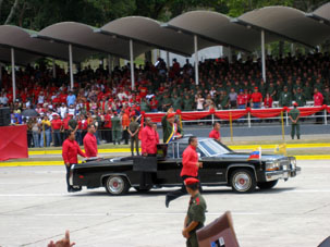 Автомобиль с президентом республики и почётными бегунами рядом.