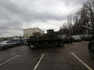 Tanque de guerra antiguo en estacionamiento de vehículos.